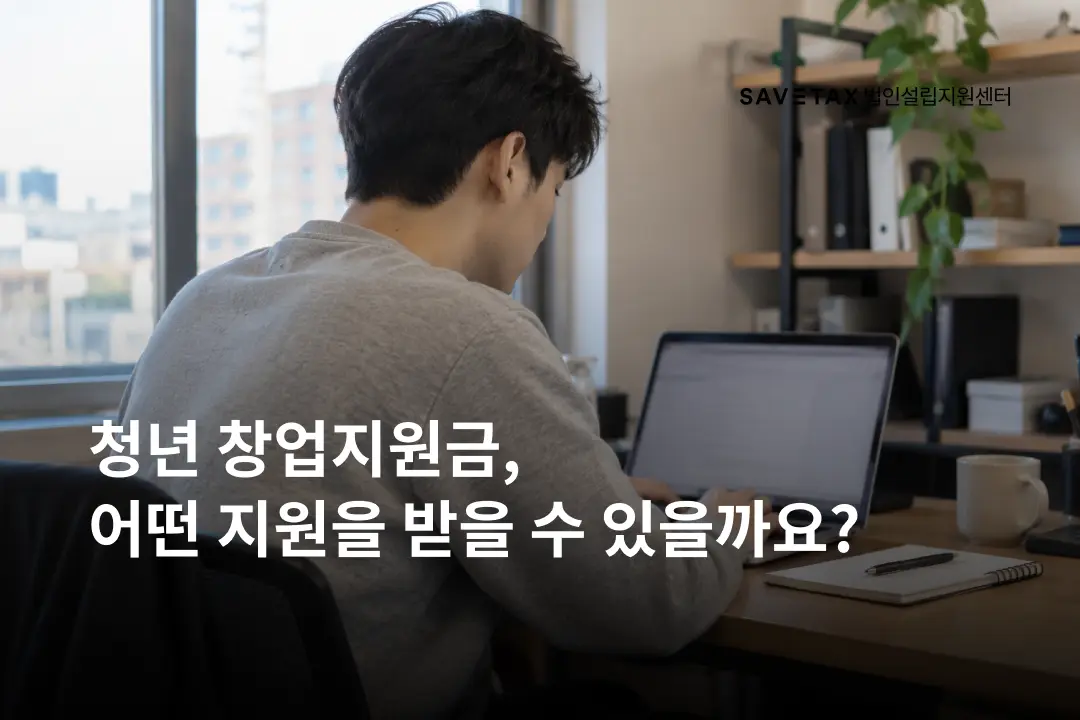 창가 책상에 앉아 노트북으로 작업하는 회색 상의 청년의 뒷모습