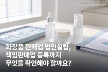 책상 위에 화장품과 등록 관련한 책이 놓여 있음