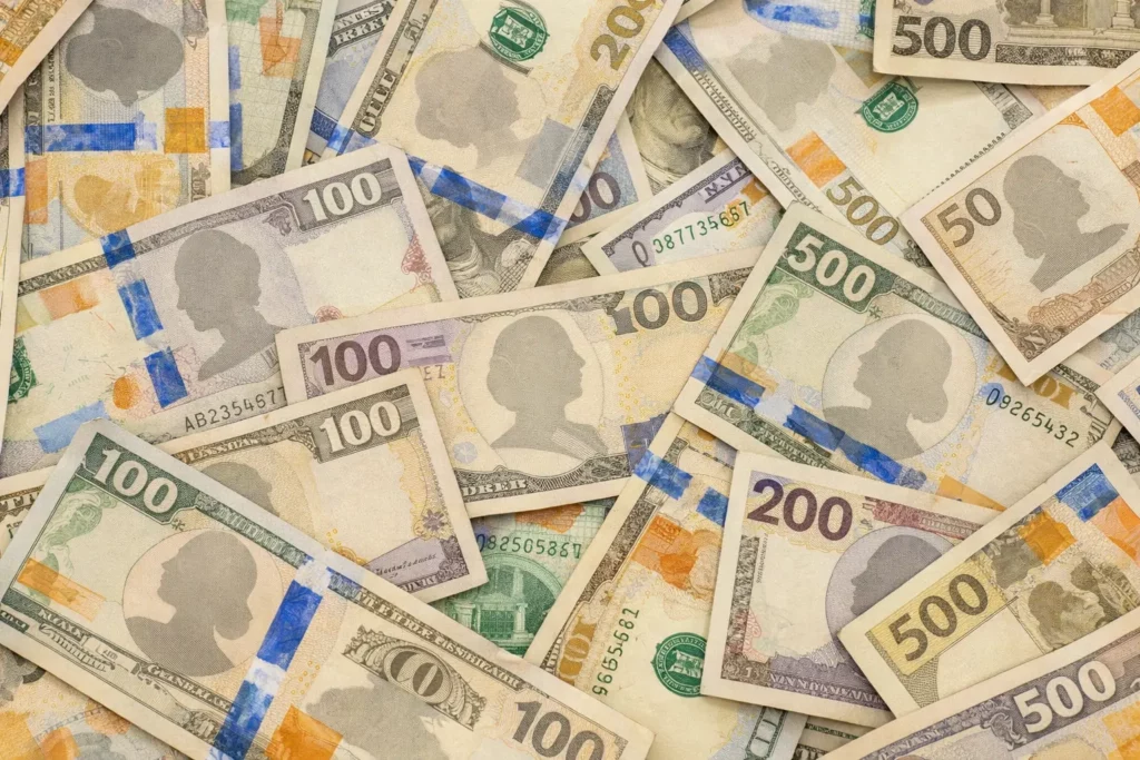 다양한 액면가의 미국 달러 지폐가 겹쳐 놓여 있는 모습으로, 100달러, 200달러, 500달러 지폐가 혼합된 클로즈업 이미지