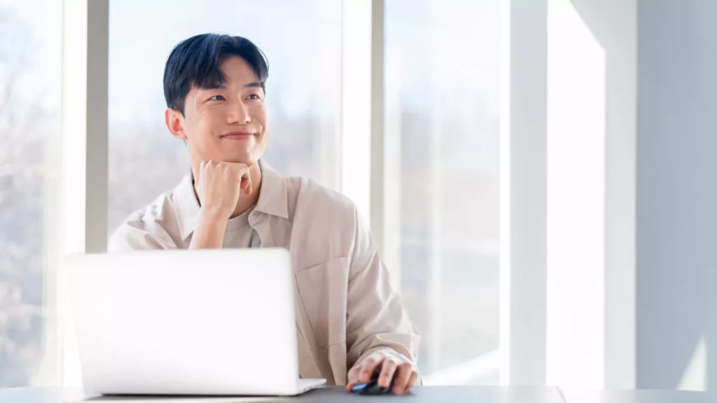 성공적인 법인 전환을 계획하며 노트북 앞에서 미소를 짓고 있는 개인 사업자 남성 모습