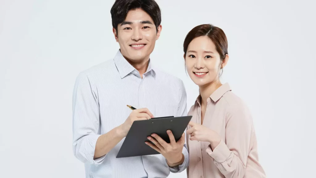 법인설립에 필요한 서류를 작성하며 환하게 웃고 있는 두 남녀의 모습